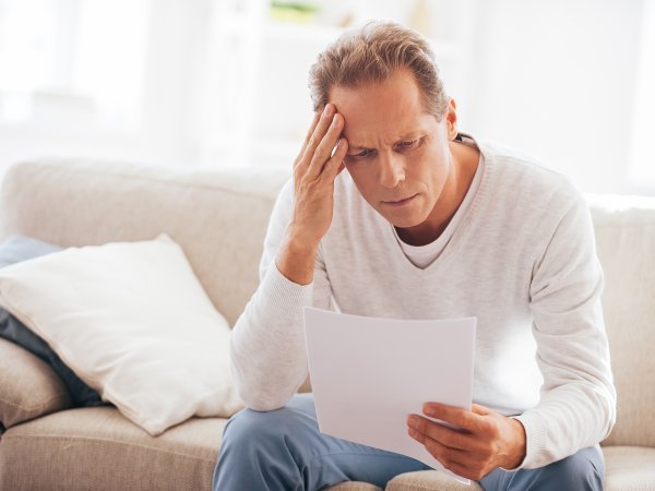 Mann liest eine überhöhte Rechnung. Foto: gstockstudio - Adobe Stock