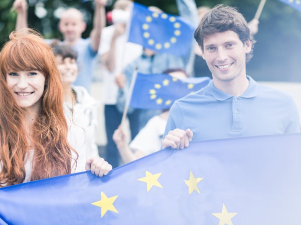 Junge Menschen mit Europaflaggen - AdobeStock - photographeeeu