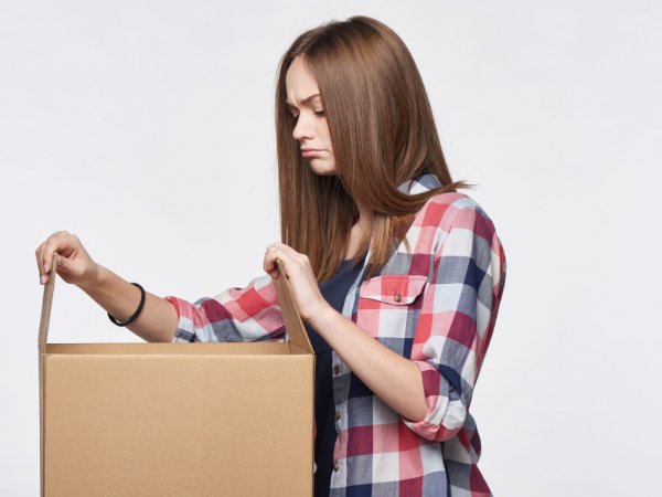 Frau schaut in Papkarton
