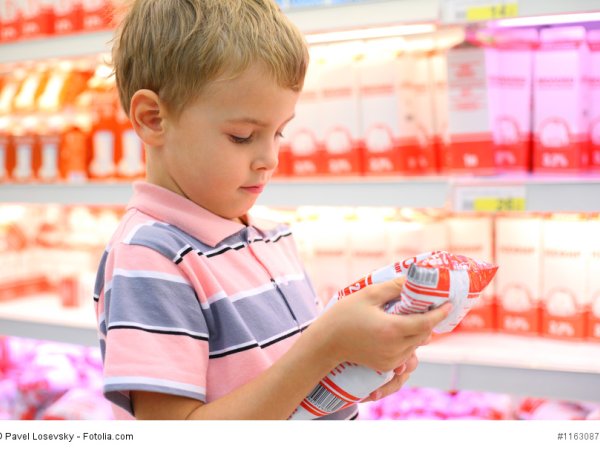 Junge im Supermarkt sich ein Produkt in seinen Händen anschauend