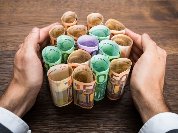 Hände halten Bargeldrollen zusammen