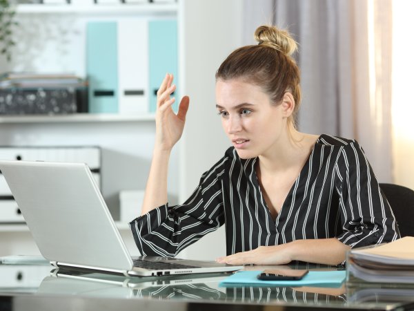 Frustrierte Frau sitzt vor einem Laptop 