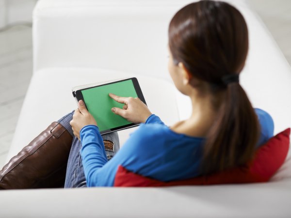 Frau sitzt vor Tablet