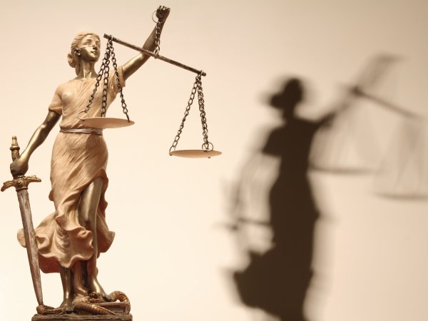 Figur der Justitia mit Schatten; Quelle: Fotolia.com / kanvag