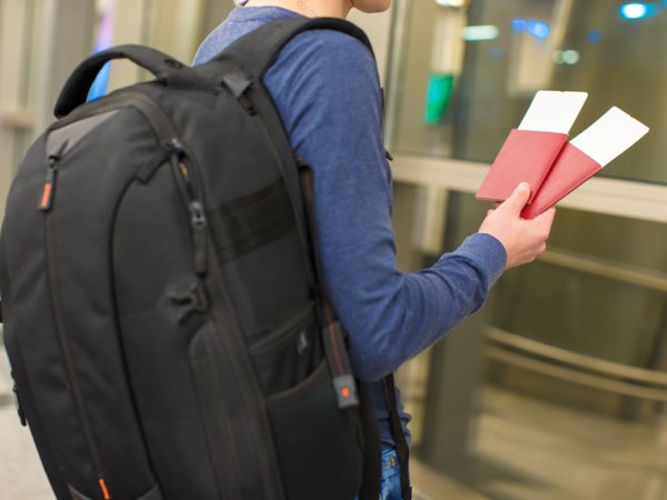 junger Mann mit Flugticket