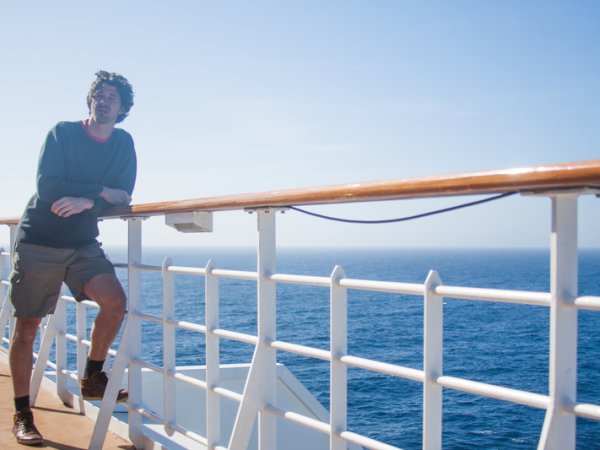 Mann steht an Reling von Kreuzfahrtschiff